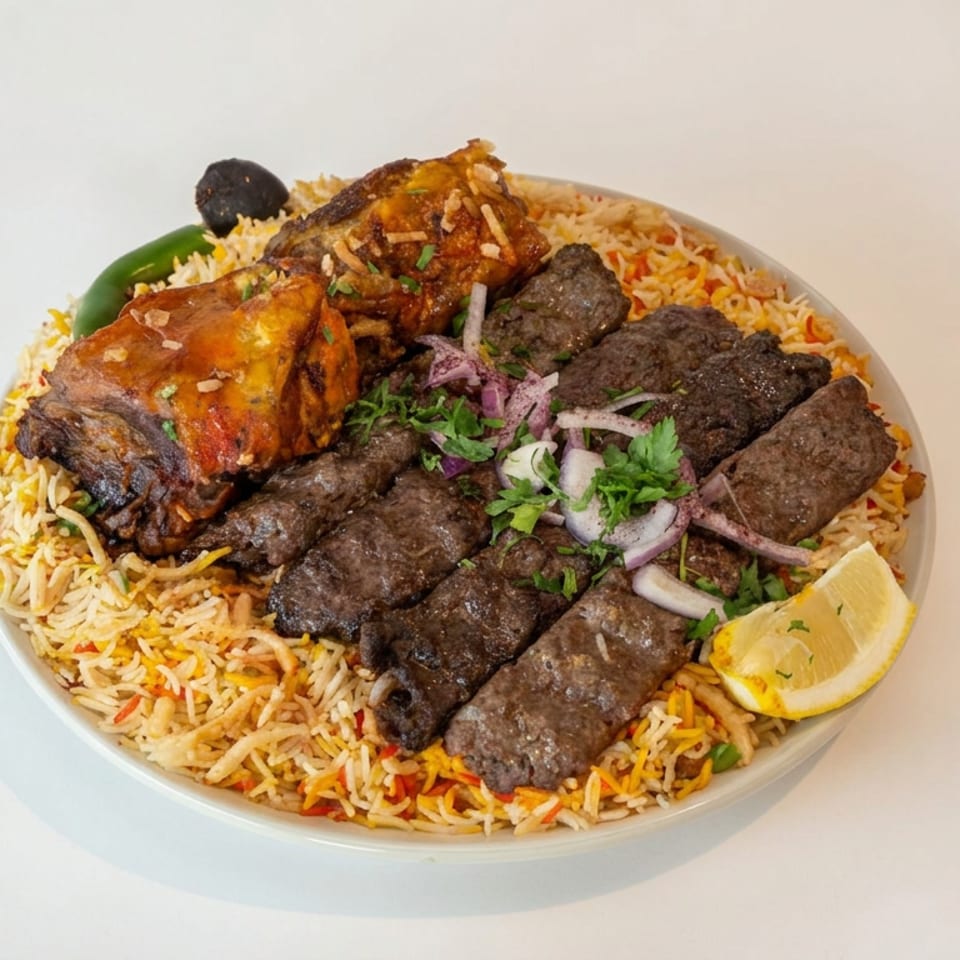 Platter of seasoned rice topped with grilled kebabs, roasted chicken, herbs, onions, chili, and a lemon wedge.